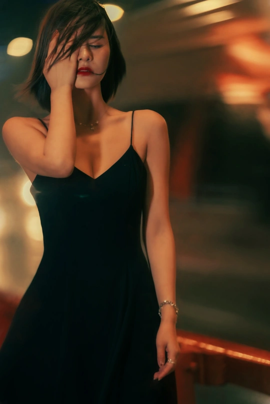 一位穿着黑色连衣裙的年轻女子 双手捂住脸