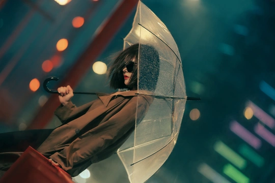 一位女士在雨中拿着红伞