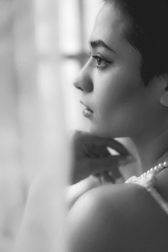 一张黑白照片 一位年轻女子在梳理她的头发。