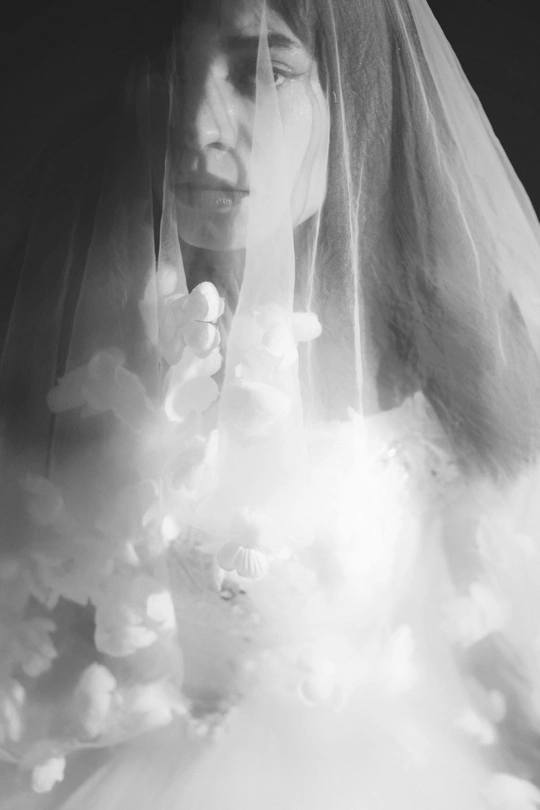 一张黑白新娘穿着婚纱和头纱的照片