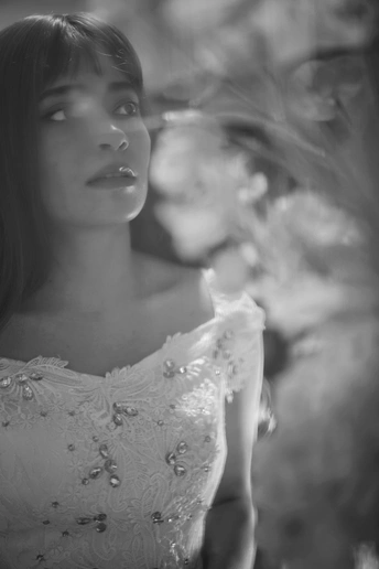 一位年轻女子穿着白色连衣裙的黑白色肖像 正对着镜子凝视