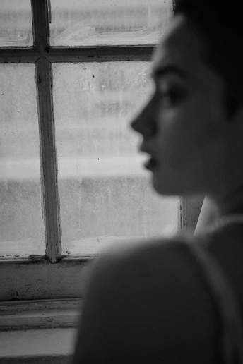 一位女士正在窗户边看着外面 另一个人也正在看着外面。