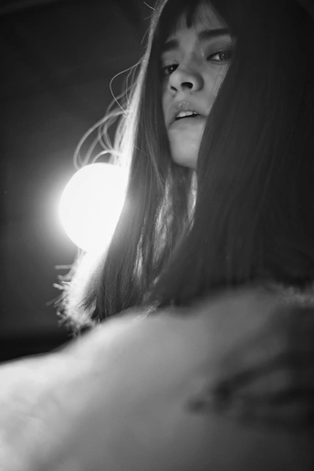 一个年轻女子在有灯光的床边