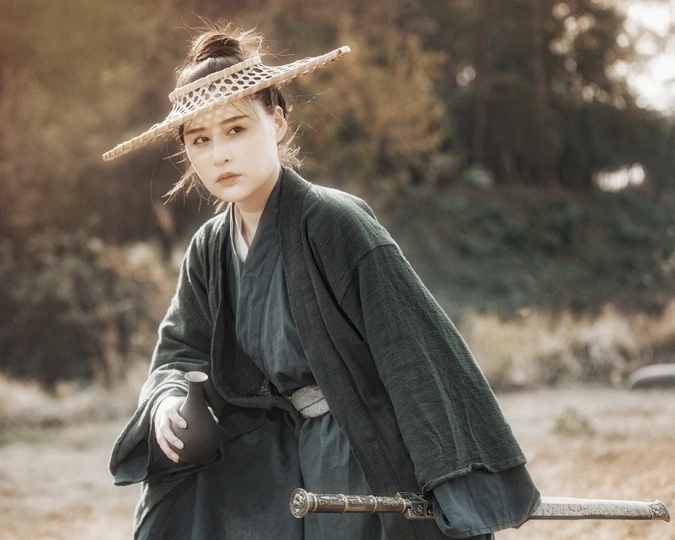 一位穿着长袍和帽子在田地里走的女人