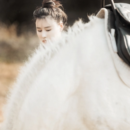 一位年轻女子骑在一匹白马上