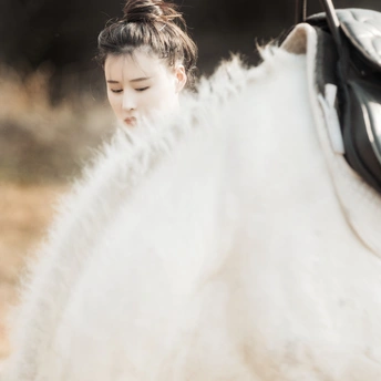 一位年轻女子骑在一匹白马上