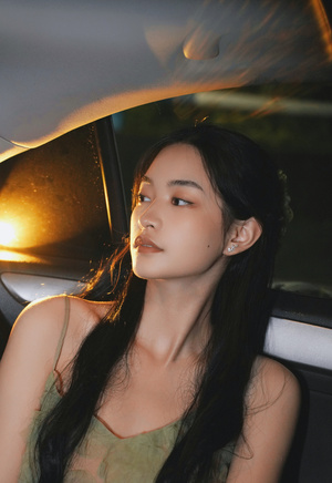 一个年轻女人晚上坐在车里 车窗里亮着灯
