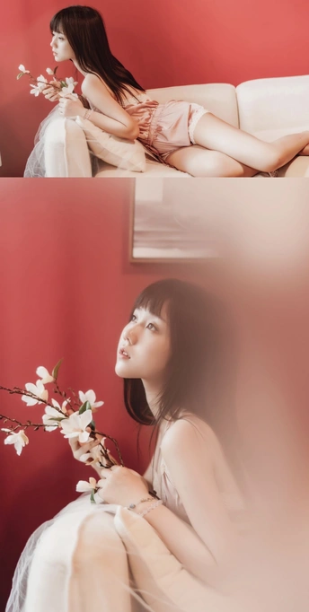 一张年轻女子坐在红色沙发上 上面放着白色花朵的照片。