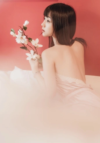 一位穿着白色连衣裙的美女手里拿着花