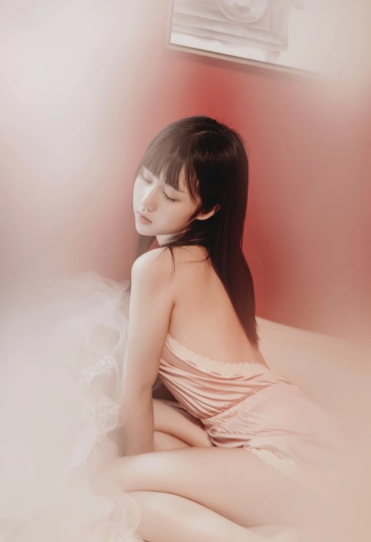 一个穿着连衣裙的年轻女子坐在床上