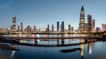 暮色或夜晚的城市 摩天大楼照亮 河景在建筑群前