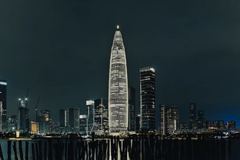 夜晚的城市 月亮在水面上 天线上有一座高塔。