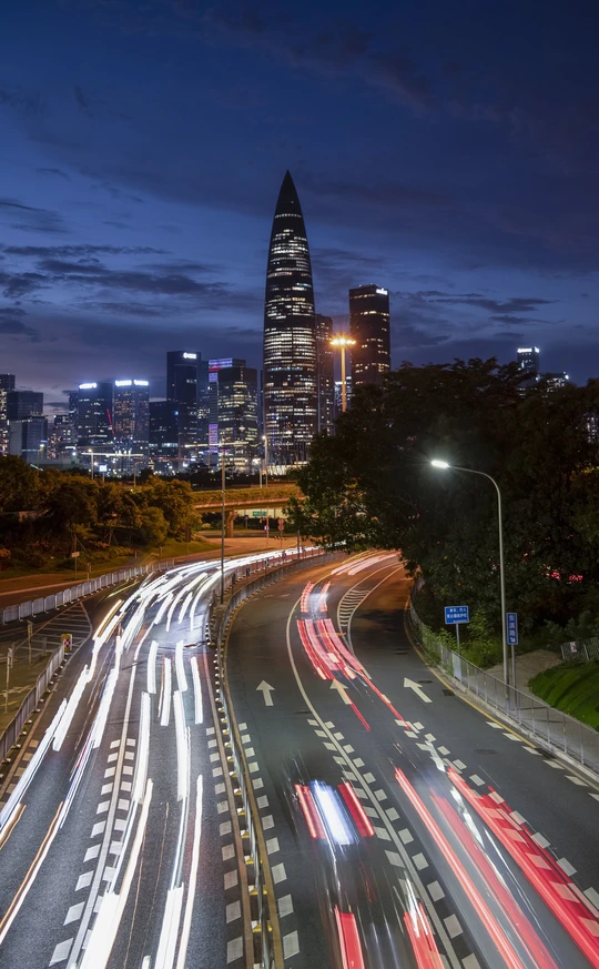 黄昏或夜晚的城市 有高耸的建筑物轮廓和轻度的交通。