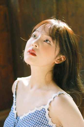 一位身穿蓝白相间连衣裙的年轻女子摆出姿势拍照