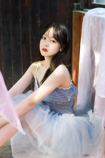 一个穿着蓝色连衣裙的年轻女子坐了下来