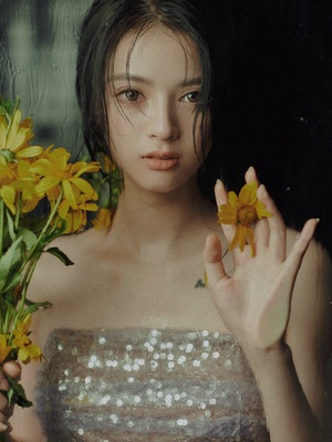 一个穿着连衣裙的年轻女子手里拿着黄色的花朵