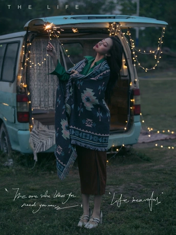 一个穿着和服的女人站在一辆车灯环绕的汽车前