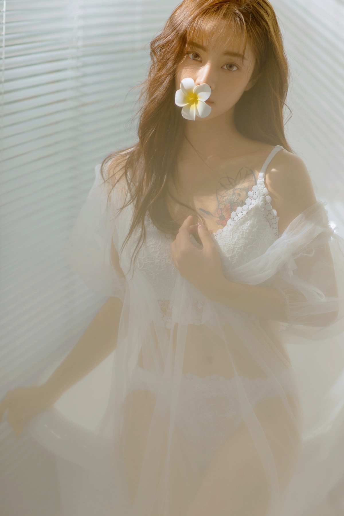 一个穿着白色连衣裙的年轻女子 头发上插着一朵花