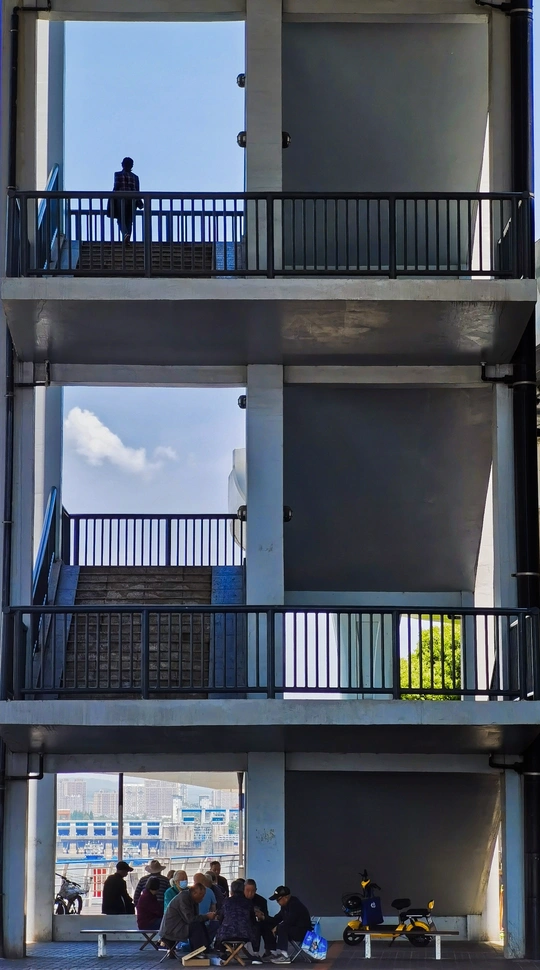 人们在阳光明媚的一天坐在建筑物外面