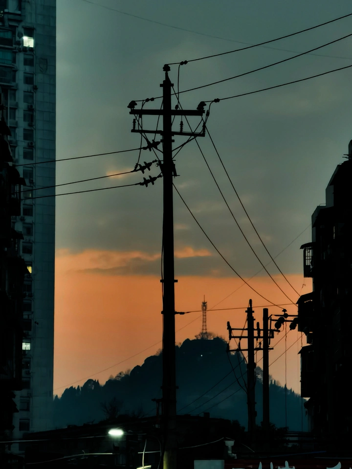 从楼宇间看夕阳下的山
