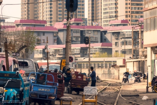 一条街道 有汽车、卡车、人和建筑。