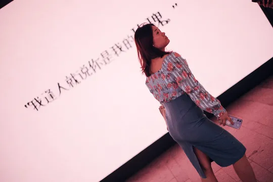 一位站在屏幕前看着模型的女性