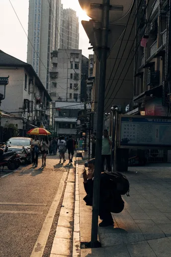 一条人行道上有行人行走 道路上停着汽车