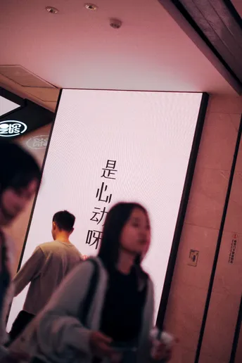 一位站在带有屏幕的墙前面的女人