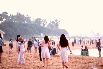 一批年轻女性沿着海滩走