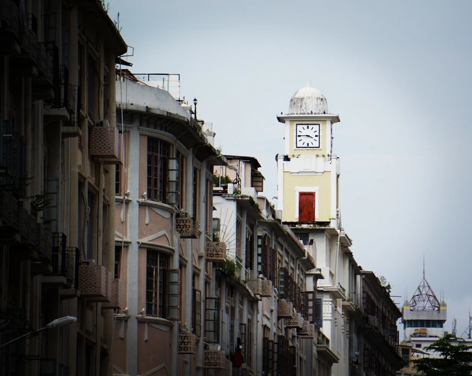 一条狭窄的城市街道 有高楼和顶部有一座白色钟楼。