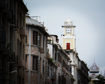 一条狭窄的城市街道 有高楼和顶部有一座白色钟楼。