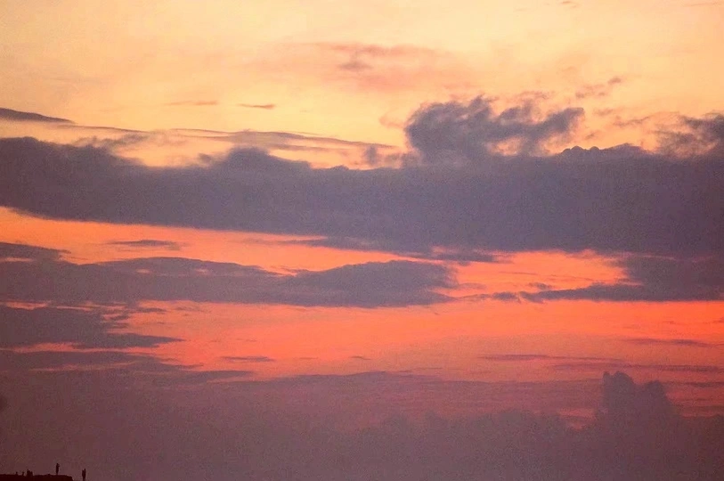 夕阳西下 天空中云朵飘过 海面泛起金光