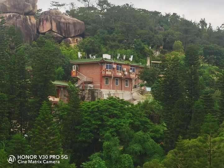 山顶上的房子被树木和岩石环绕的森林