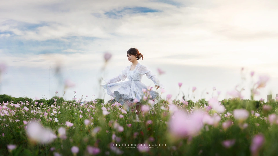 一位美丽的年轻女子穿着白色连衣裙穿越一片紫花田