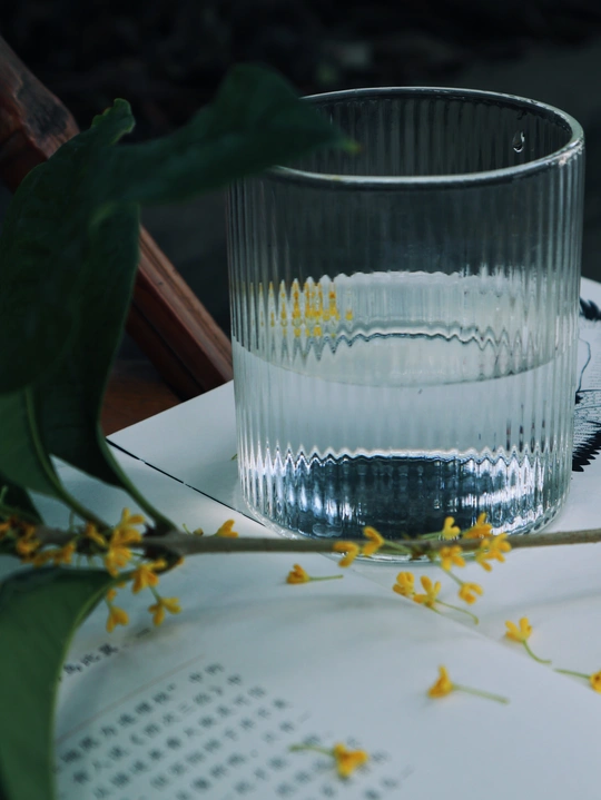 a clear glass of water sitting on top of a white p