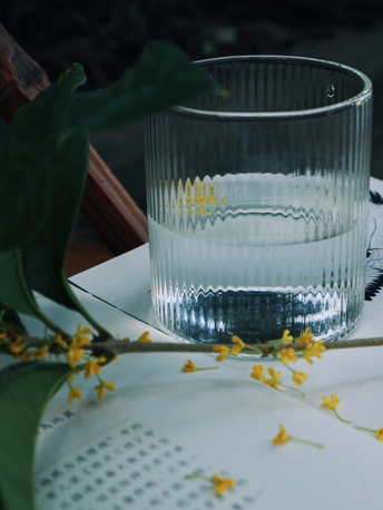 a clear glass of water sitting on top of a white p
