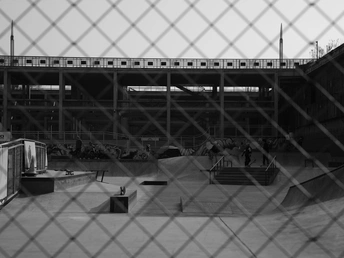 一个人在滑板公园骑滑板 其他人 behind a fence