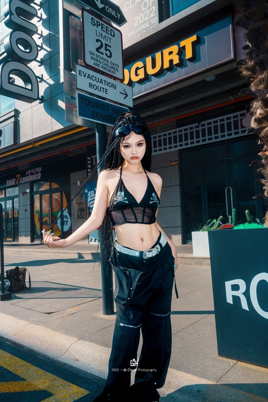 一个穿黑色裤子的女人站在城市街道的人行道上