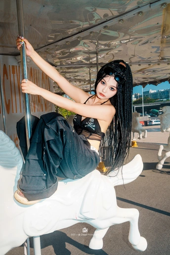 骑着黑色马在游乐园旋转木马上年轻女子