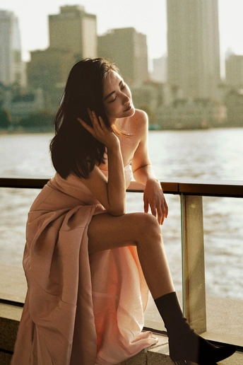 一位穿着连衣裙的年轻女子坐在水边