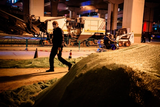 一个人在夜晚经过一个建筑工地的大型岩石