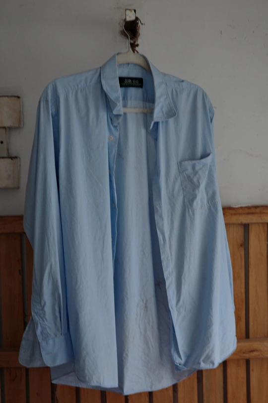 蓝色衬衫挂在白墙上