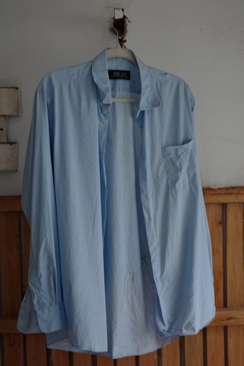 蓝色衬衫挂在白墙上