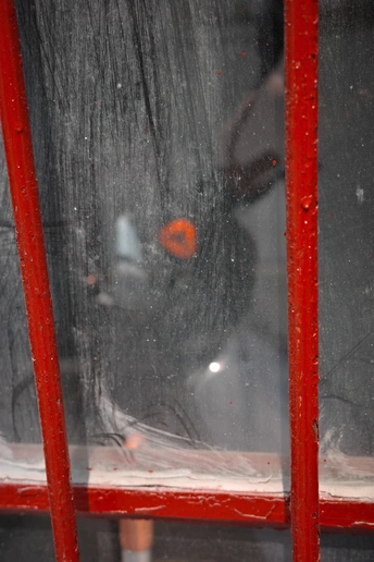 一个红色的电话亭 有一个人带着伞的倒影