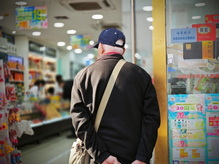 一个戴帽子的人拿着一个袋子在商店里走