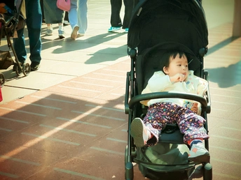 一个小孩子推着婴儿车在商场里