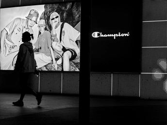 一张黑白照片 一对男女站在一面墙前的屏幕前行走。