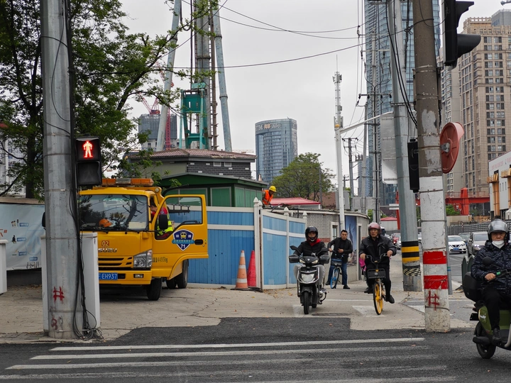 人们骑摩托车和一辆黄色卡车在城市街道上