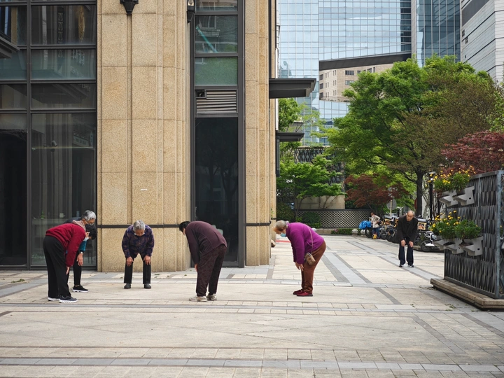 一些人在人行道上站在一栋建筑旁边