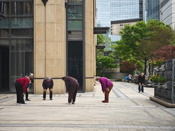 一些人在人行道上站在一栋建筑旁边
